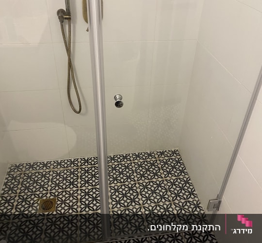 מקלחון עם אריחים מעוצבים ודלת זכוכית